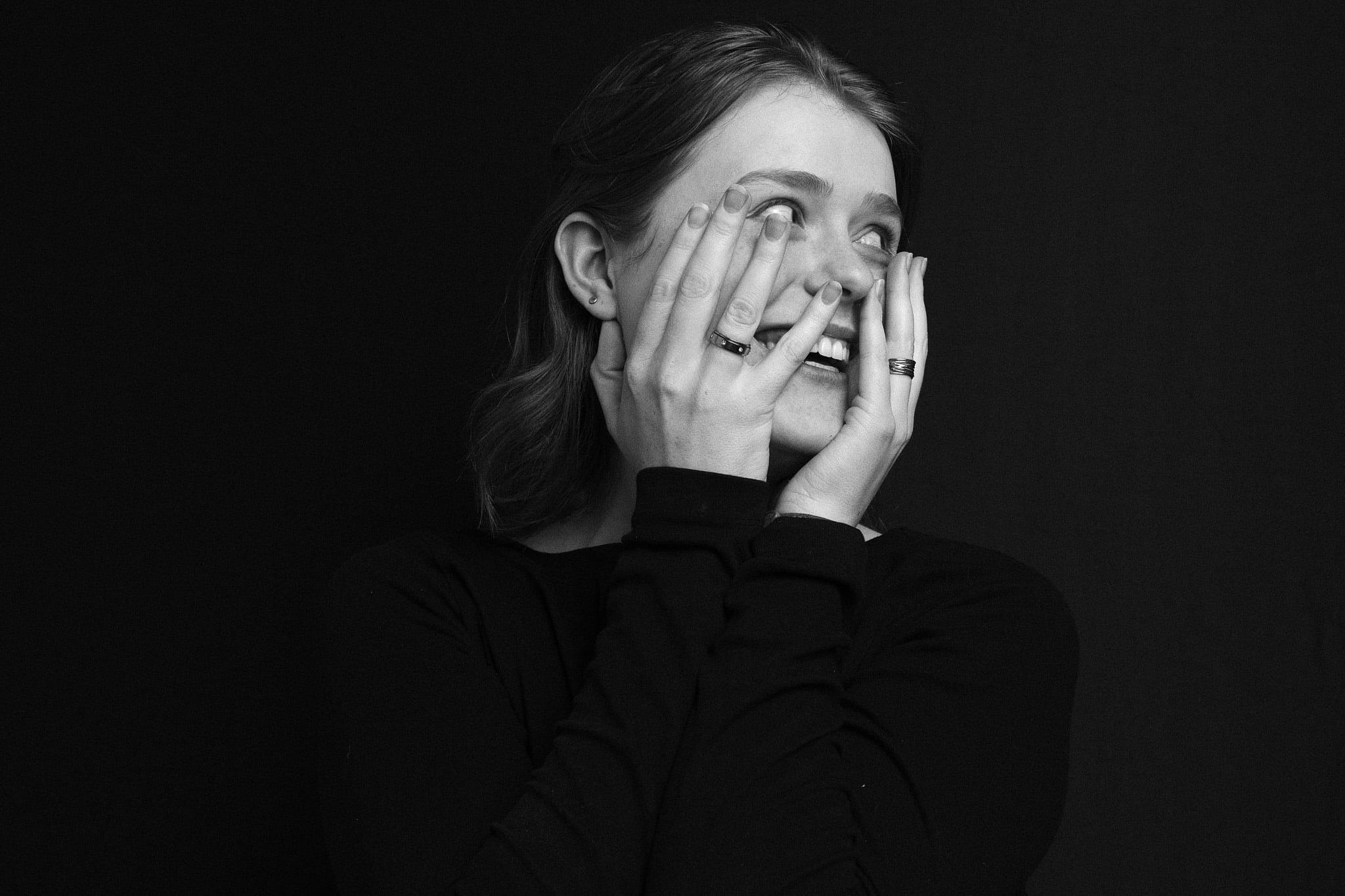 The woman covering her face with her hands, laughing.