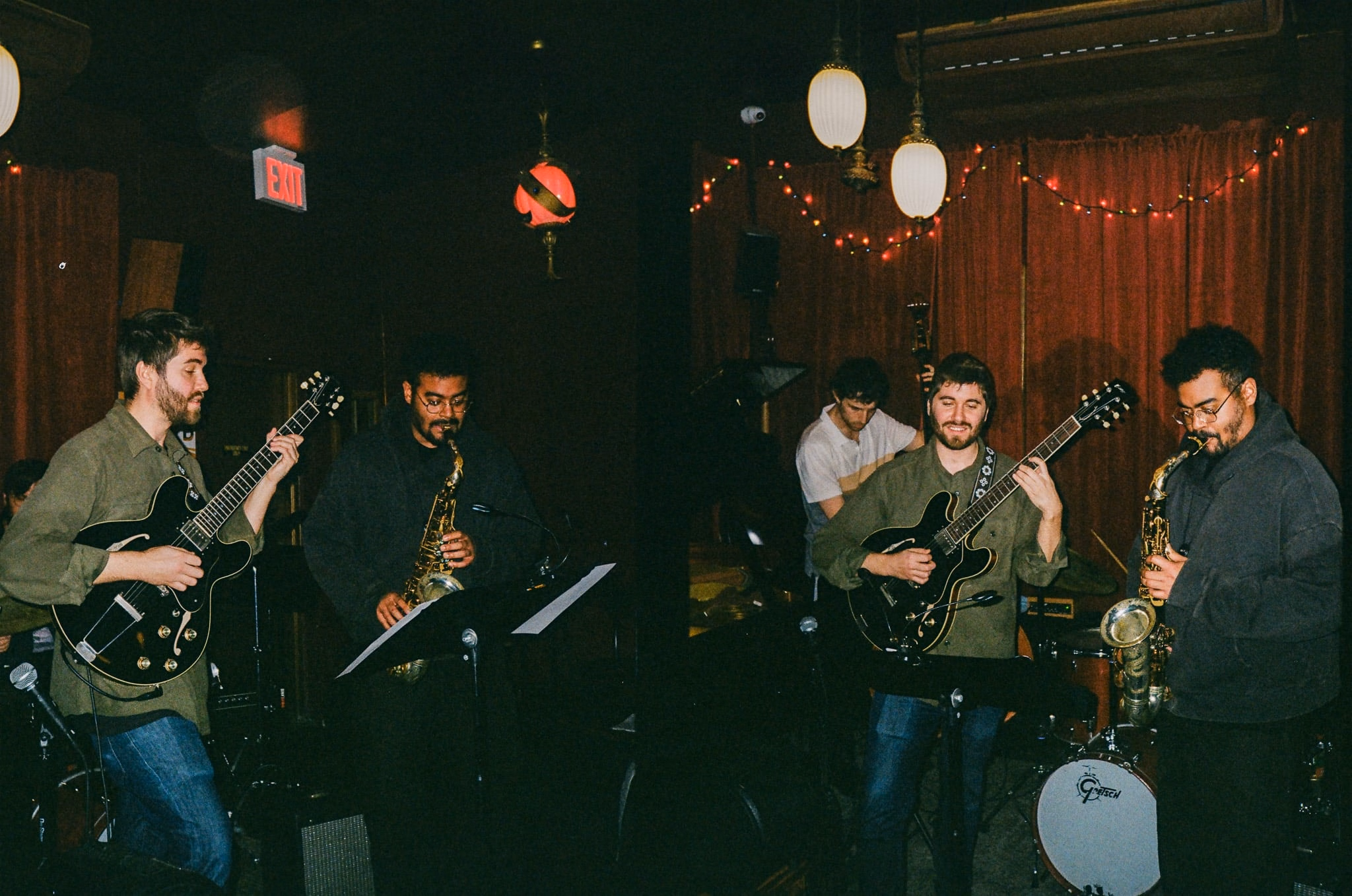 A band packed into the corner of a bar under string lights.